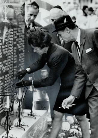 Monument To 6,000,000, Stefa Noble and Sam Silverstein lit candles yesterday at Mount Siai Memorial Gardens cemetery after unveiling of monument to 6,000,000 Jews exterminated by the Nazis