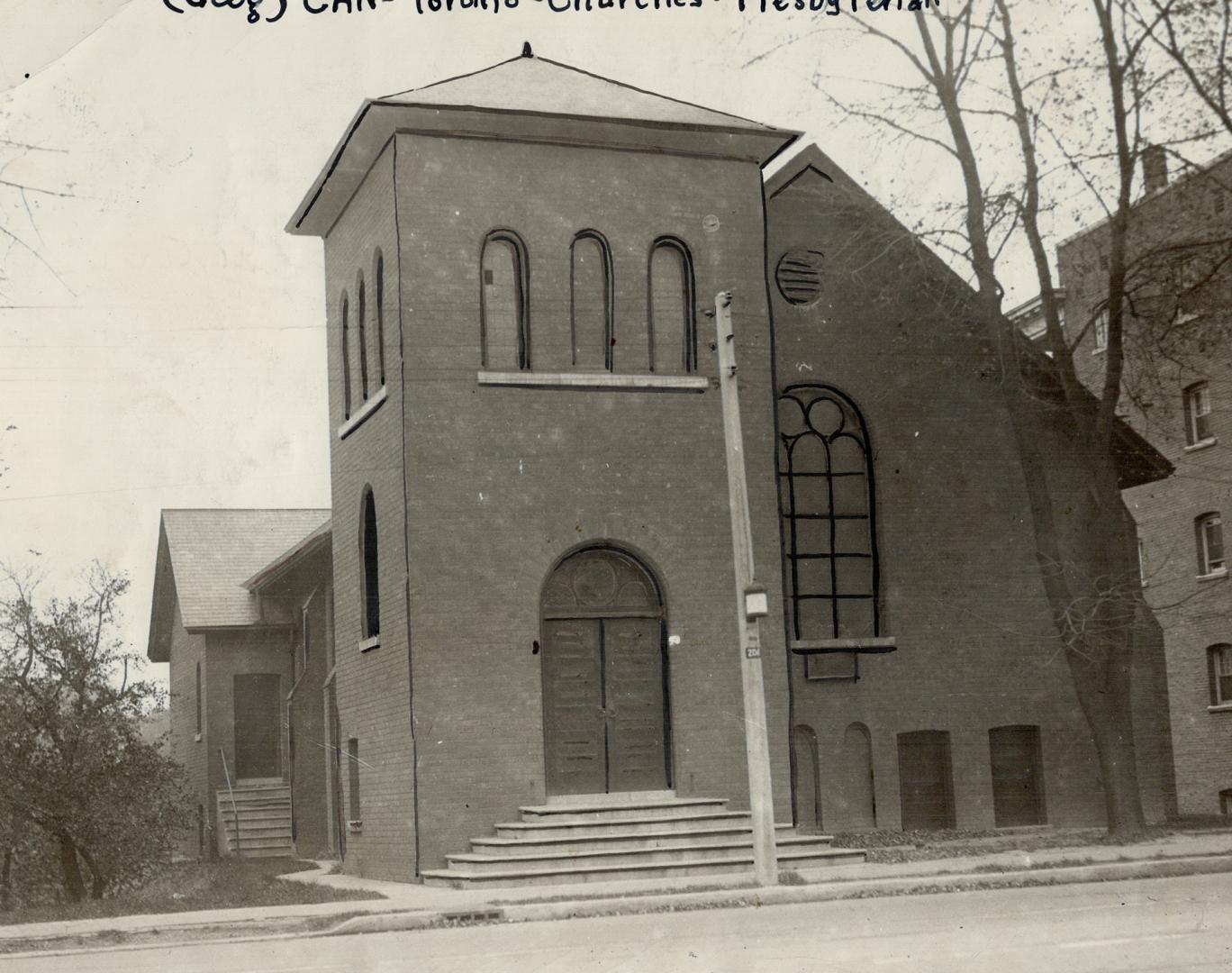 Exterior of brick church with prominent belfry tower over front entrance. Steps lead to double …