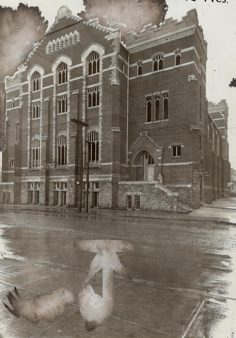 Exterior of three-storey brick church with stone foundation.