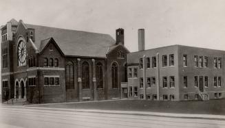 Exterior of brick church in background with modern addition in the foreground.