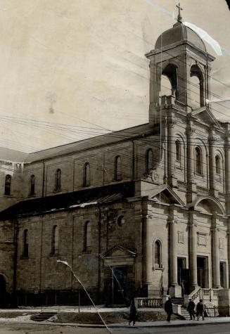 View showing front and side of exterior of stone church, with steps leading to entrance doors b…