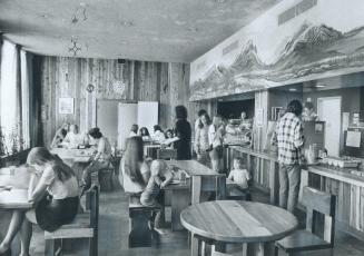 Residents and visitors eat and read in the restaurant area of Rochdale College