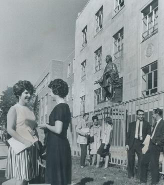 Students chat in front of Egerton Ryerson statue after registering