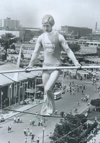 120 feet above Canadian National Exhibition Jay Cochrane, the Canadian Prince of the Air, walks a tightrope from the Hockey Hall of Fame to the roof o(...)