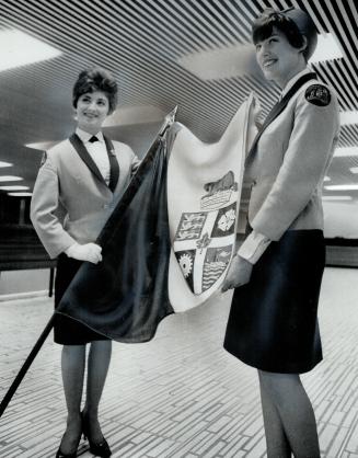 City hall guides Sally Lester (left) and Jacqueline Kappen show Toronto's new blue-and-white city flag, which Mayor William Dennison says isn't a flag at all