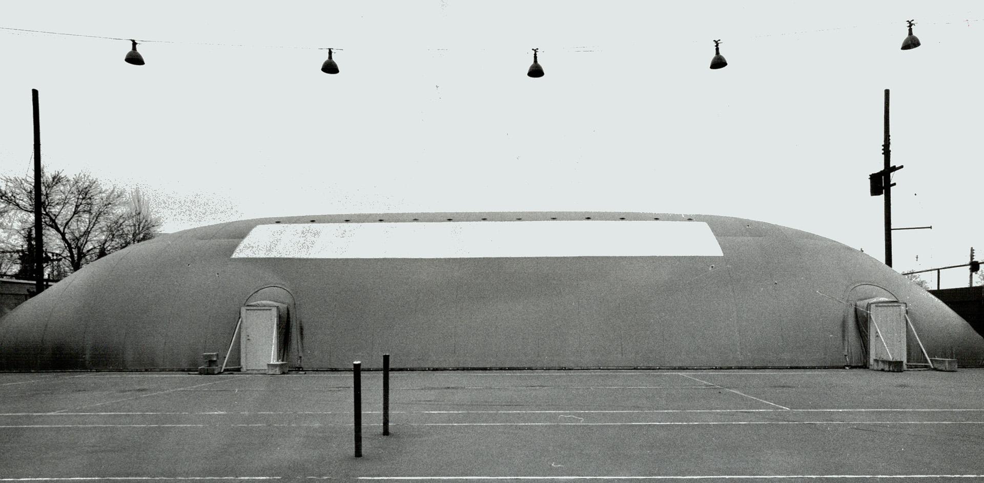 Tennis is a balloon, Club pro Jim Bentley (foreground) and Ken Sinclair play tennis in Swedish-designed air-supported dome at Toronto Cricket, Skating and Curling Club