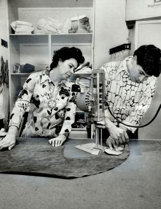 Rita, Frank Osawabine cut suede at George Brown College, The Ojibwa from Manitoulin Island are learning how to work with hides and fur