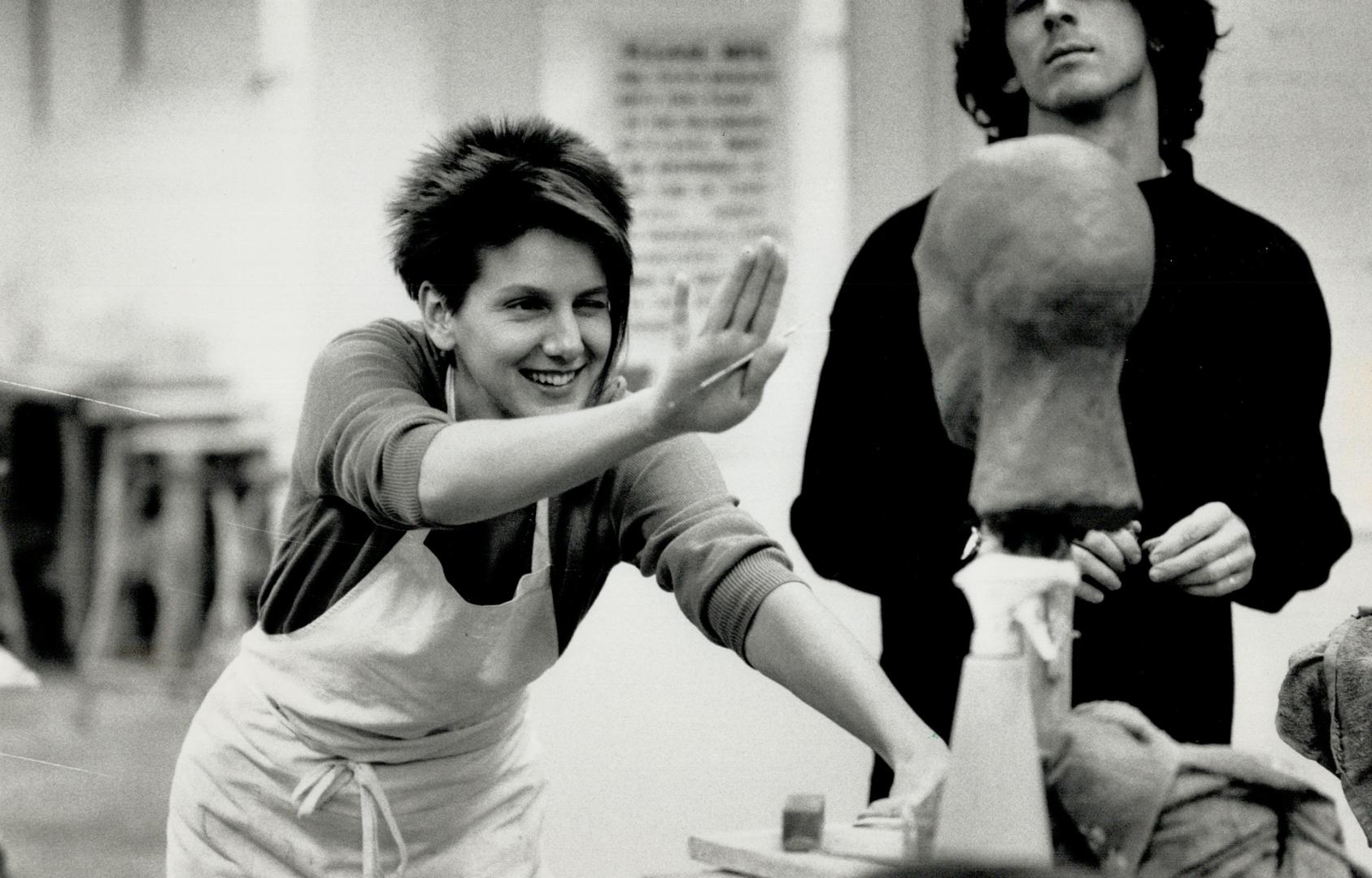 Heads up: Student Edith Dakovic (left) casts a critical eye as she checks the alignment of the facial features of a clay bust she is working on during a sculpting class