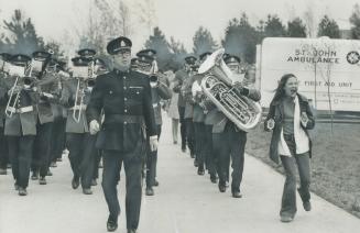 Keeping in step with the band, Undampened by the weather, which was chilly, windy and wet at Ontario Place yesterday, Patty McNiven, 13, skips along b(...)