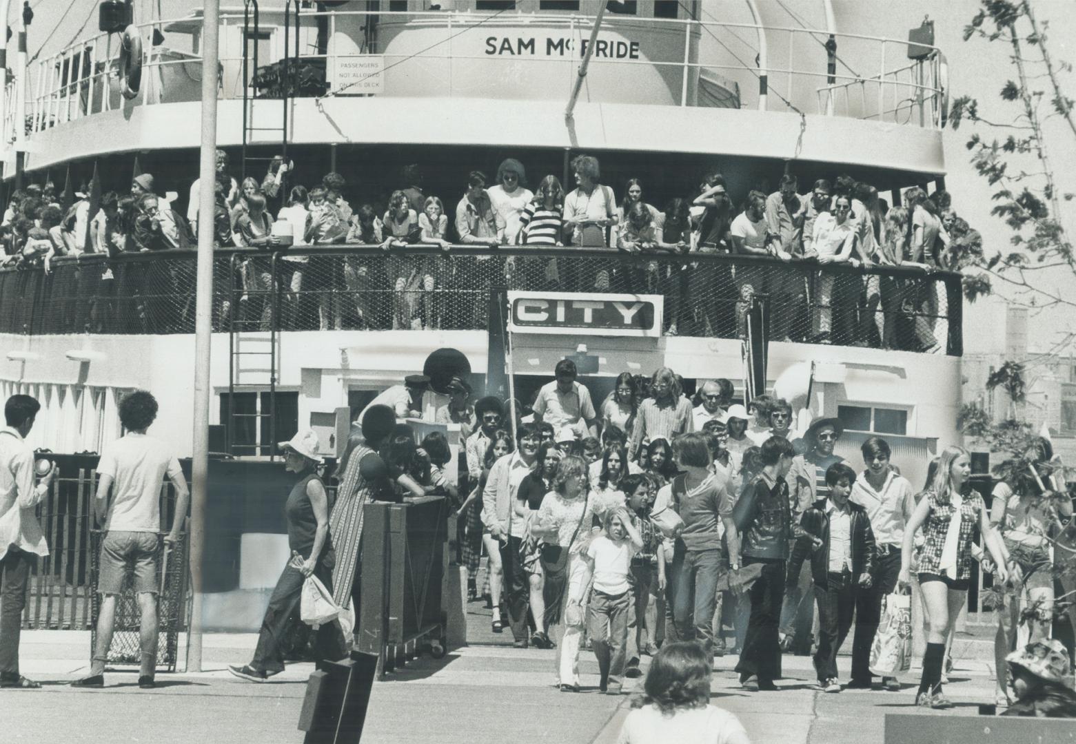 Crowds pour off the ferry at Queen's Quay as others wait to board during hectic summer months