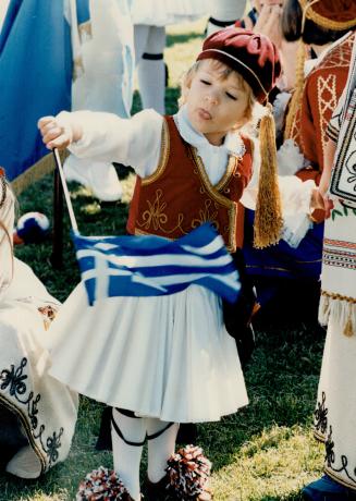 Tony Bitzionis, 3 1/2, dressed in traditional costume, waves the Greek flag on Danforth Ave