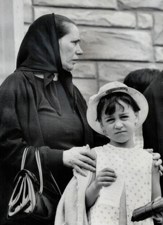 Contrasts mingle in Italian-Canadian community as grandmother in traditional shawl guides granddaughter