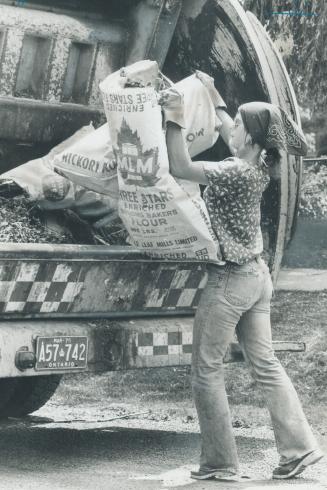 Grinding work faces Mary Livaja, 18, one of three women hired by the North York public works department this summer to collect garbage. Summer jobs th(...)