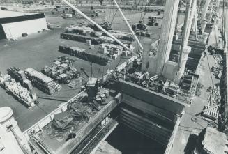 Image shows the top of a cargo ship with some containers around it.