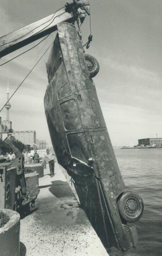 Image shows a limousine being pulled out of the lake.