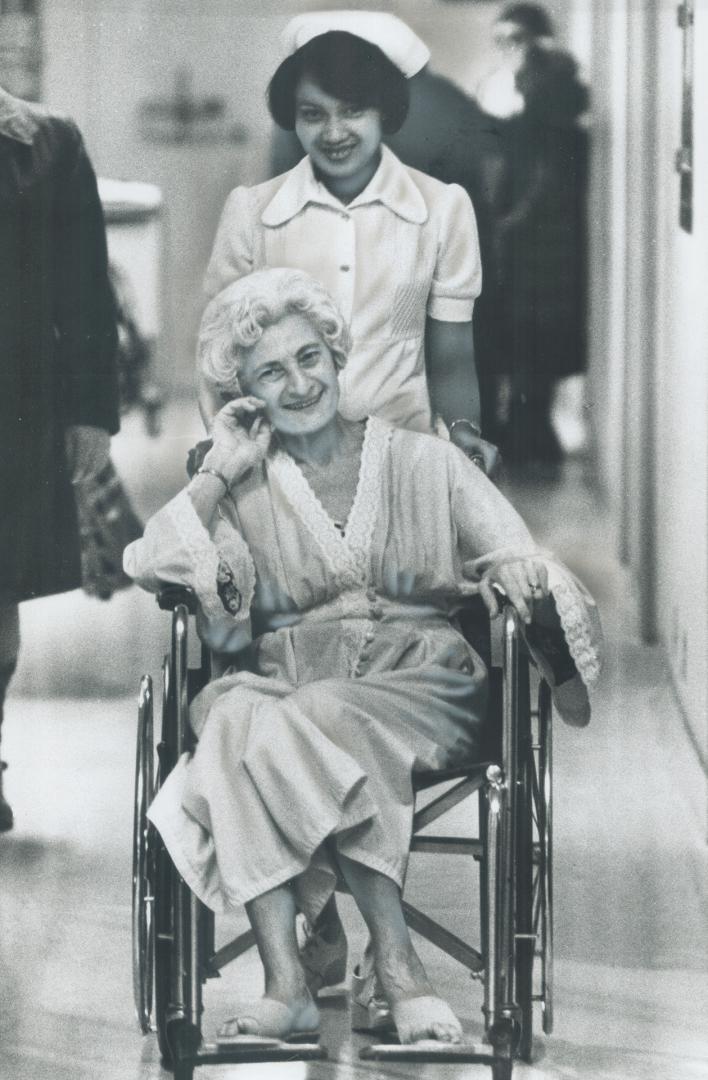 Sonya Taylor, a patient, smiles as Nurse Victoria Hospital Fabella wheels her along, but says its frightening that Doctors Hospital is to close