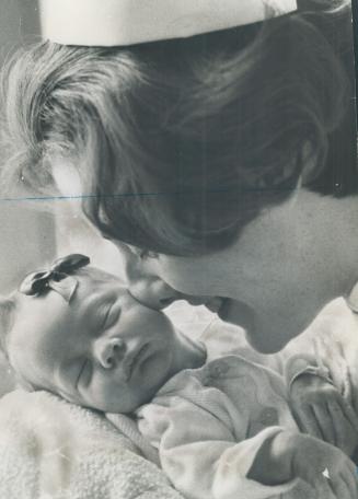 Nurse Lynn shoemaker lovingly nuzzles premature baby Stephanie Lynch