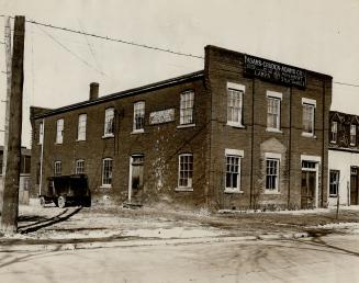 Two-storey brick building. Sign above second floor windows reads, Adams-Cruden-Adams Co. - Wood…