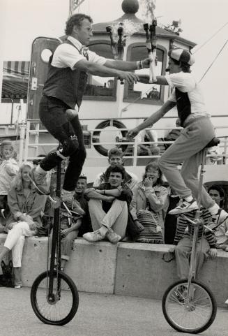 Tricky business: Cyrus Koski, left, and Benji Marantz, doing unicycle turn, wow audience at Harbourfront as part of festival of international Street Performers