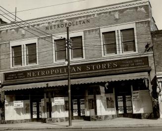 Two-storey brick building; sign above window awning reads, Stores from Coast to Coast, Metropol…