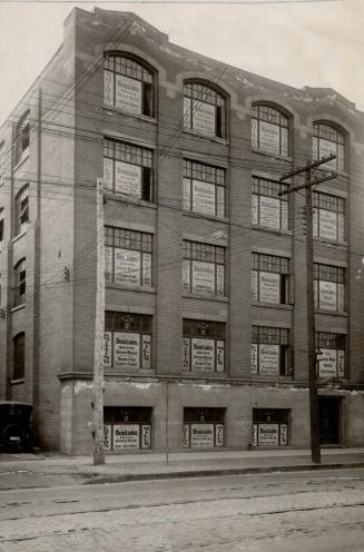 Exterior view of five-storey brick building with large, evenly spaced windows.