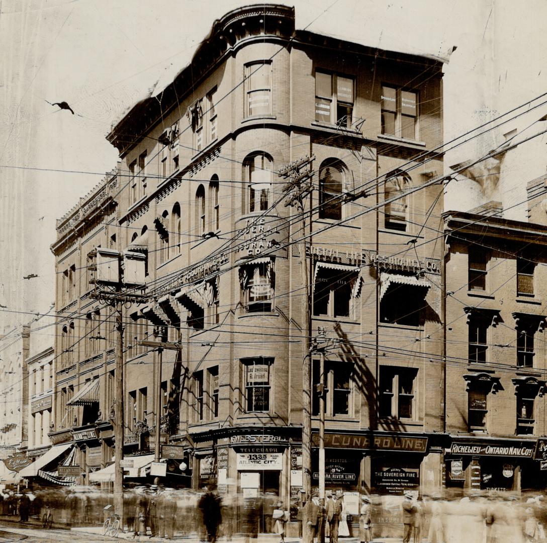 Corner view of five-storey brick building at intersection.