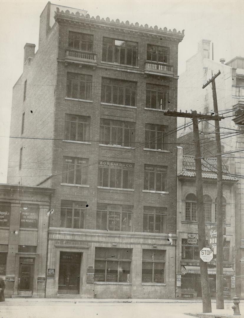 Exterior view of six-storey brick building with signs behind windows reading, Pellatt - Campbel…