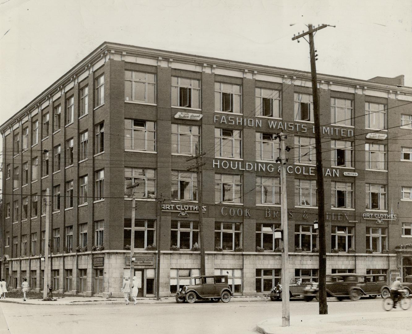 Exterior view of five-storey brick building. The following company names are mounted to wall be…