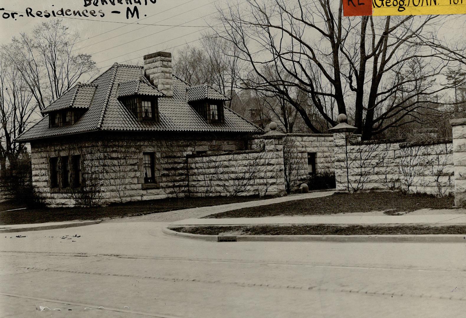 Two-storey stone structure with shingled roof, dormer windows and stone chimney; attached to st…