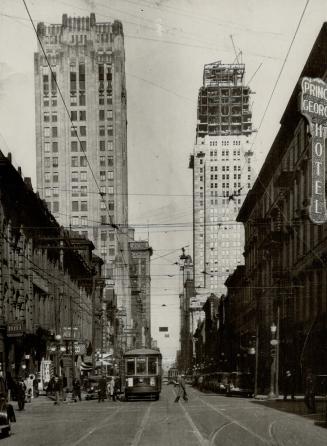 The twin towers of King St. W., Toronto. The one on the left is The Toronto Star Building, and the other is the new Bank of Commerce Skyscraper, now nearing outward completion