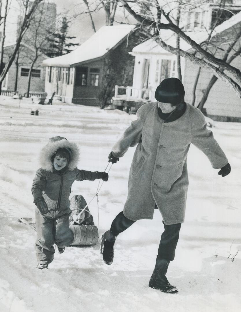 Irvin Waller and his daughters, Ginnie, 5, and Kate, 3, play on the clean snow of Algonquin Island