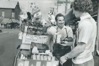 Joe Amaro buys popcorn from Franco Grosso in Kensington Market, an area that adds to Toronto's cosmopolitan air