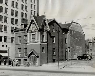 This is the home of 53. Fifty-three people live in one Toronto house. The red brick, three-storey, moderately large residence stands on Carlton St. be(...)