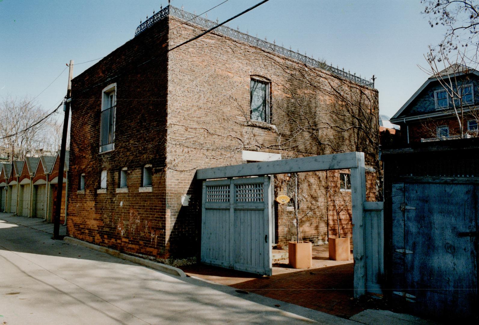 Brick boxfacade: A gate opens on to the plain, box-like exterior of th gorgeous coach huse of Barbara Gordon and Bob Bermann