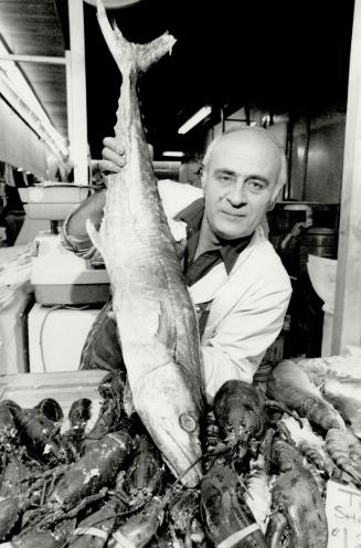 Finned beauty: Gus Chappins, a fish and meat vendor at the market for 30 years, displays a prime barracuda