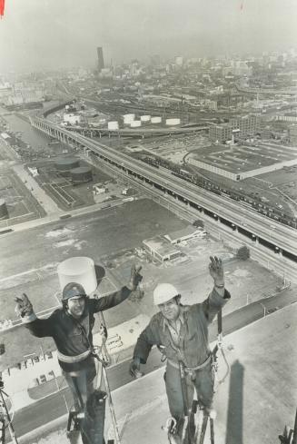 Okay sign from 450-feet up. Riggers Fern Morin, left, and Emile Lebond, gave okay signs yesterday as they finished last foot of 450-foot incinerator c(...)