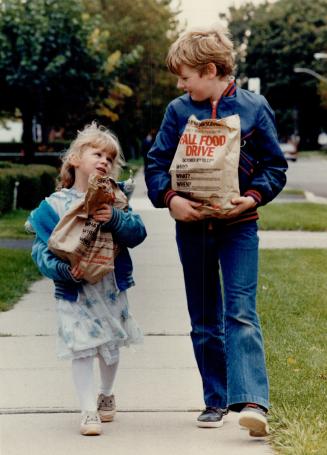 Heavy load: Laura Leonelli, 4, and Gregory Sullivan, 10, of Etobicoke, haul food to school