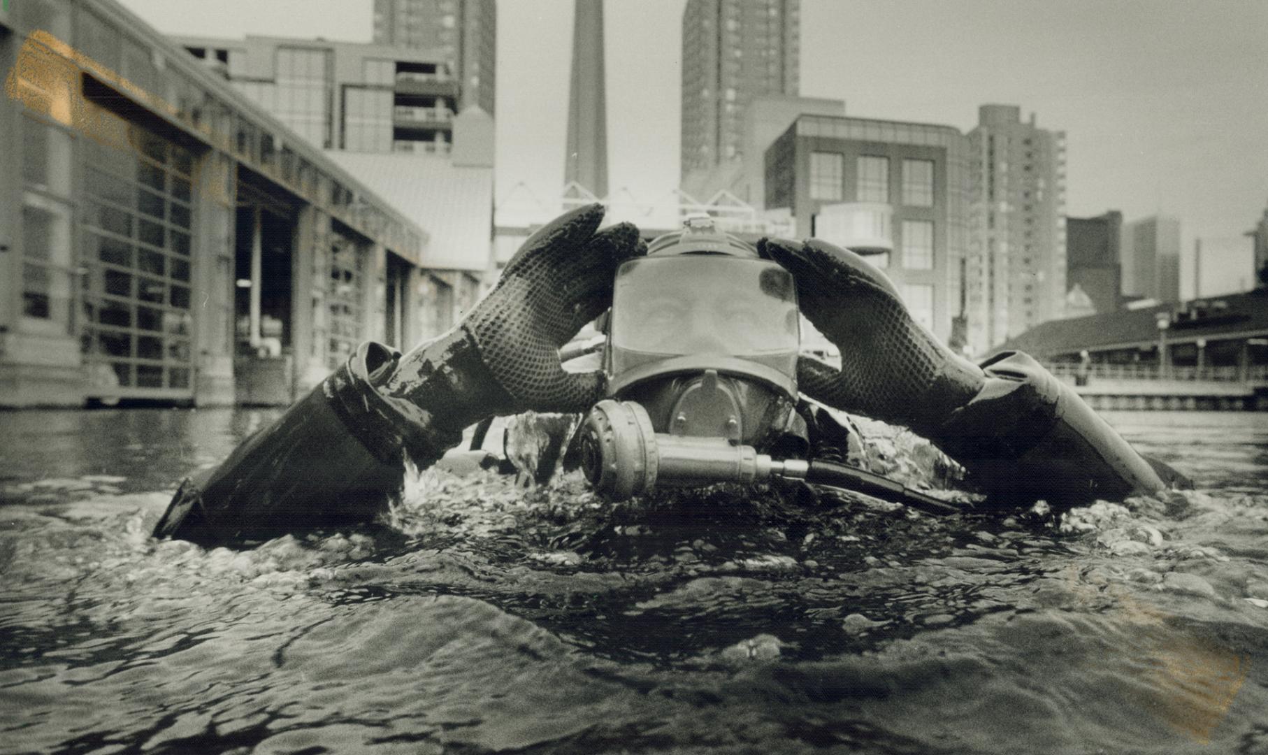 Forever blowing bubbles. Sergeant Martin Hunt of the Metro police marine unit adjusts his goggles before diving to install underwater pipe around the (...)