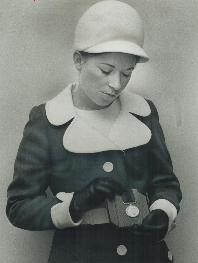 Mrs. David Goldsworthy, whose husband was shot to death while investigating a break-in, shows the medal of honor he was awarded by police commission