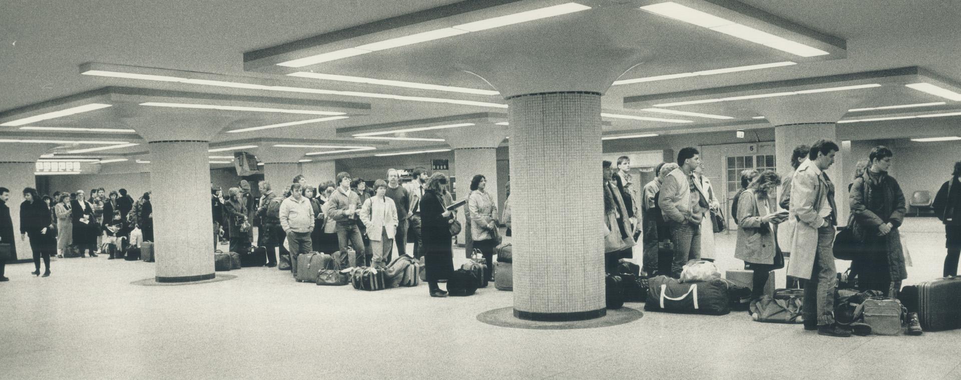 A lengthy lineup of rail passengers wait to board trains at Union Station - what some call the 'cattle line