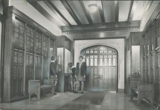 Bishop Strachan girls gossip in a panelled hallway