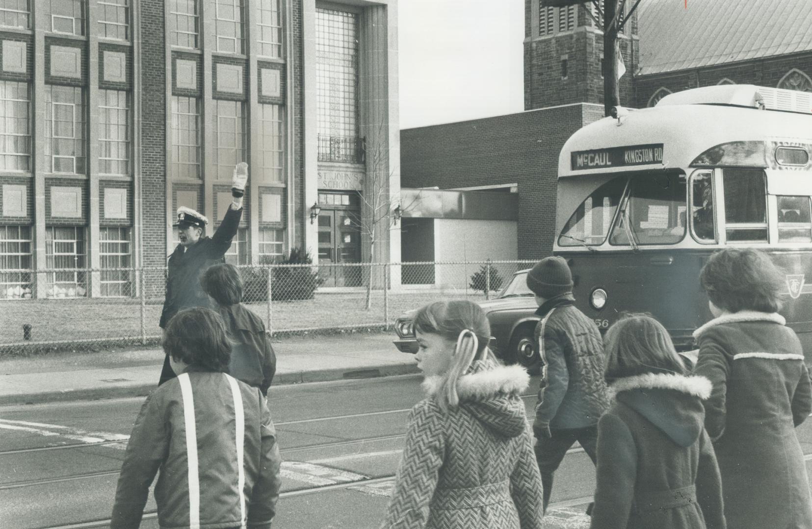 Police cadet Lyn Chapman stops traffic on Kingston Rd