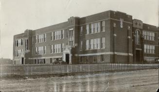 Exterior view of three-storey, flat-roofed brick building.