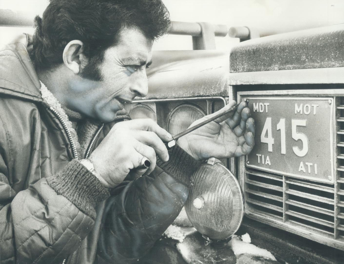 Special permit plate allowing him to pick up passengers at Toronto International Airport is affixed to right side of his grill by taxicab owner Razek (...)