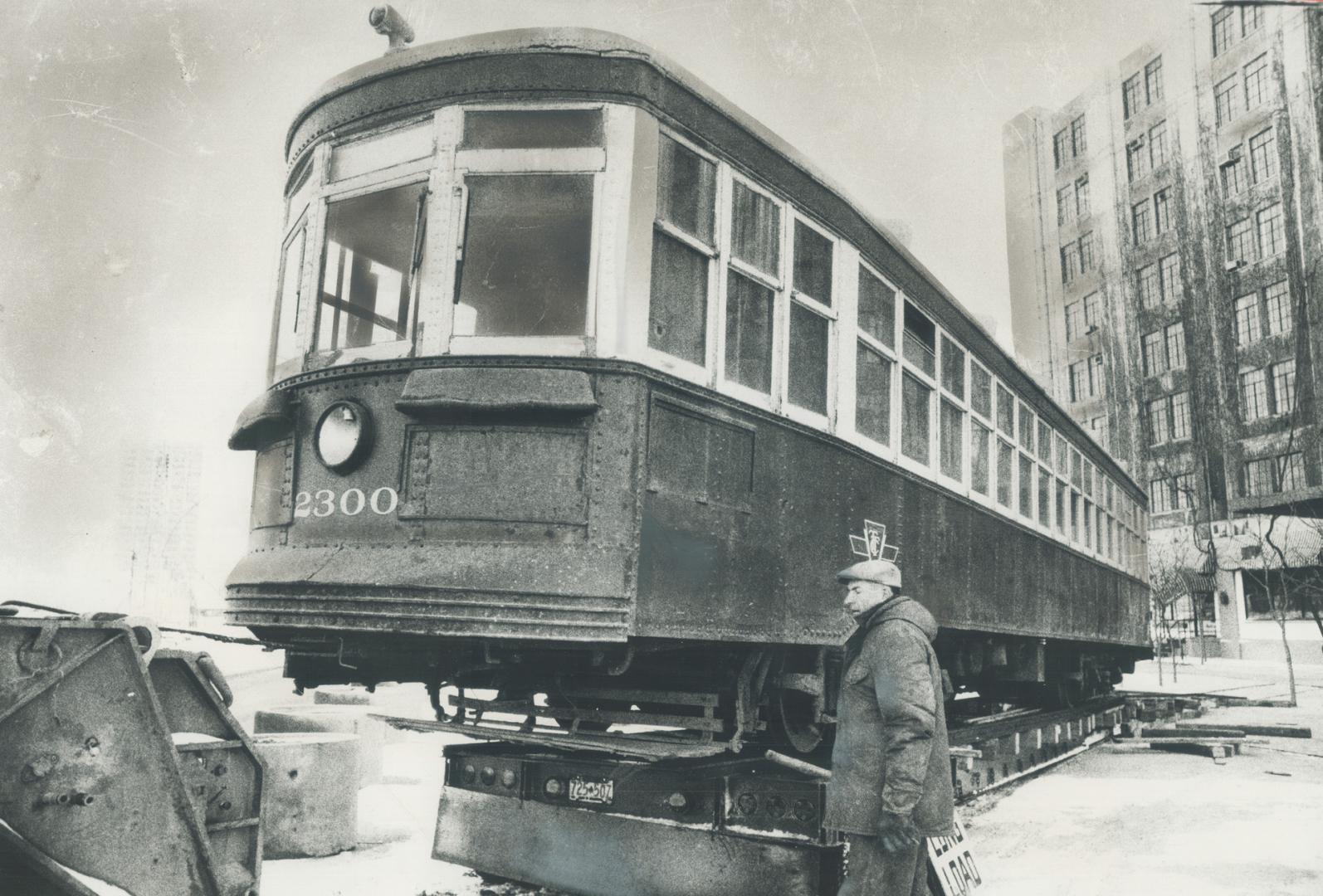 Railroaded into history. On its way to a museum, this 1921 Peter Witt-type streetcar is inched off the flatbed of a transport truck on to tracks at Qu(...)