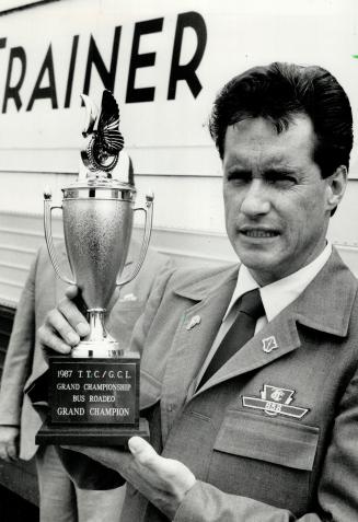 Ride 'em cowboy! Bill White of the TTC's Queensway Division holds the trophy he lassoed for placing first in the annual bus roadeo. White, 34, raced a(...)