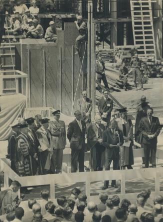 A Constructive talk. Workman pause to listen as Prince Philip gives an address at Massey college where he laid the foundation stone today. The college(...)