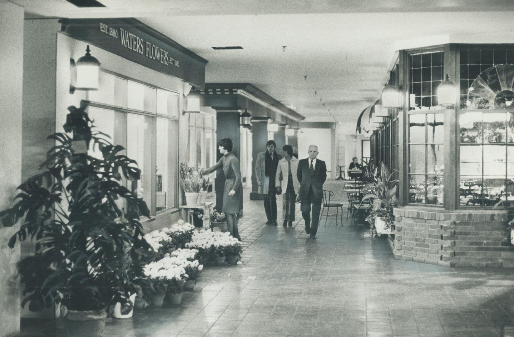 Gray skies and chill winds of Toronto's winter seem far away as pedestrians stroll and a girl arranges flower display in the new section of walkways u(...)