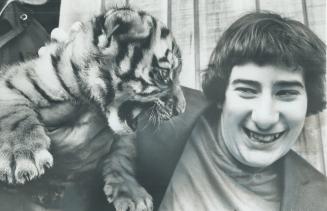 A brave smile is managed by 13-year-old Jason Gordon of Hamilton as 10-week old Siberian tiger cub at Metro Zoo tries to showits gratitude to winner o(...)