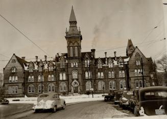 Toronto landmark, old Knox College building, recently renovated and now used as a laboratory, stands in a circular island in the centre of Spadina Ave(...)